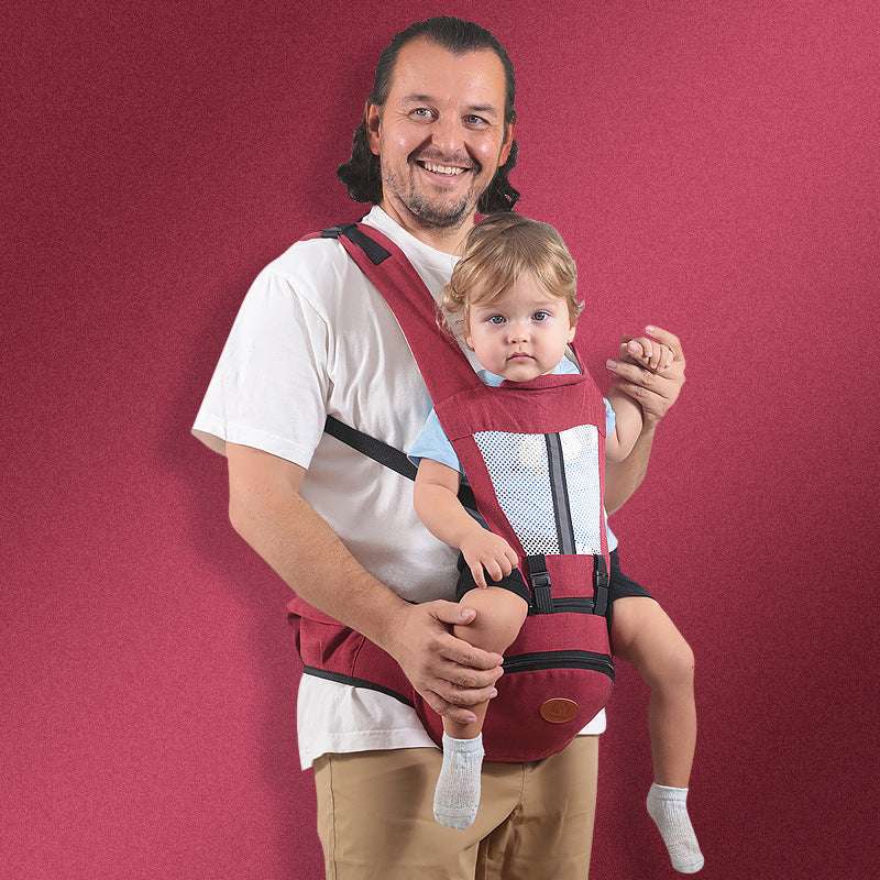 Red Baby Hip Seat Carrier with toddler seated securely, showing ergonomic design and breathable mesh. Adjustable straps for parent comfort.