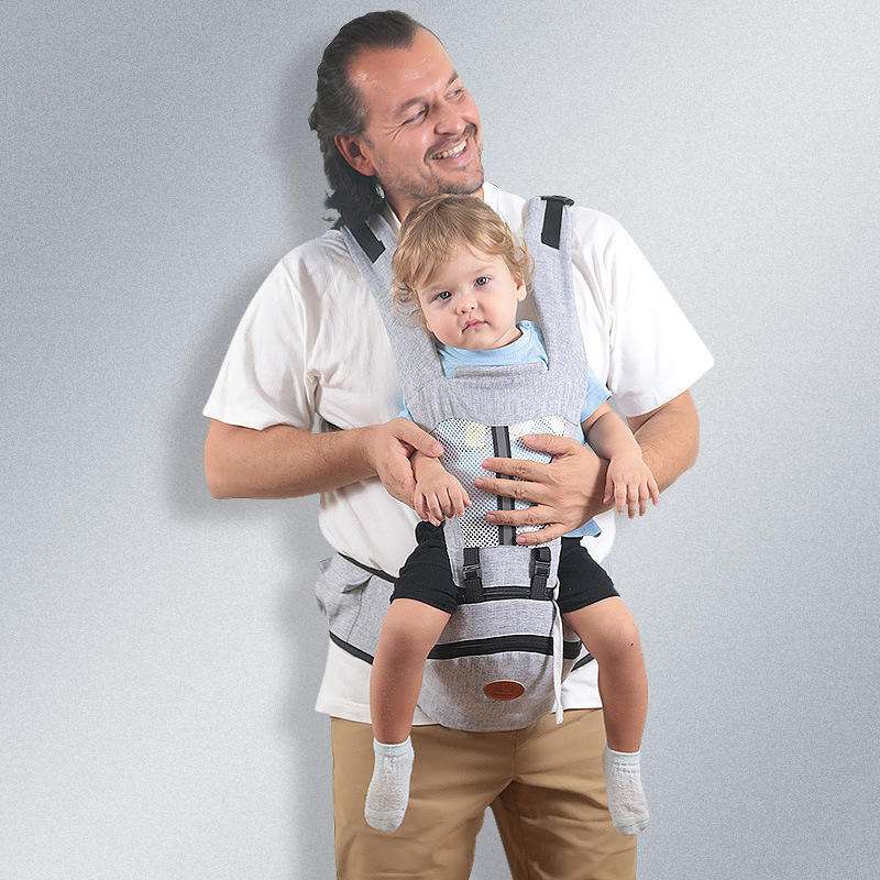 Father carrying toddler in gray Baby Hip Seat Carrier with adjustable straps and ergonomic support. Comfortable babywearing for daily use.