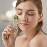 Woman using jade roller facial tool under eye area to reduce puffiness and fine lines, promoting youthful skin appearance.