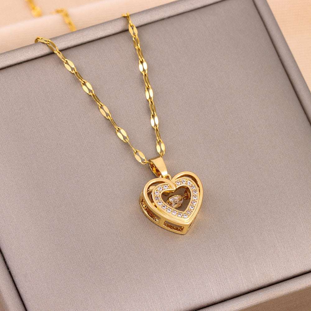 Close-up of gold Double-layer Love Necklace with rhinestone heart pendant on a twisted chain. Elegant titanium steel fashion jewelry.