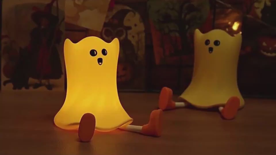 Two glowing Silicone Ghost Lamps on a wooden surface, creating a cozy Halloween ambiance with touch control and waterproof features.
